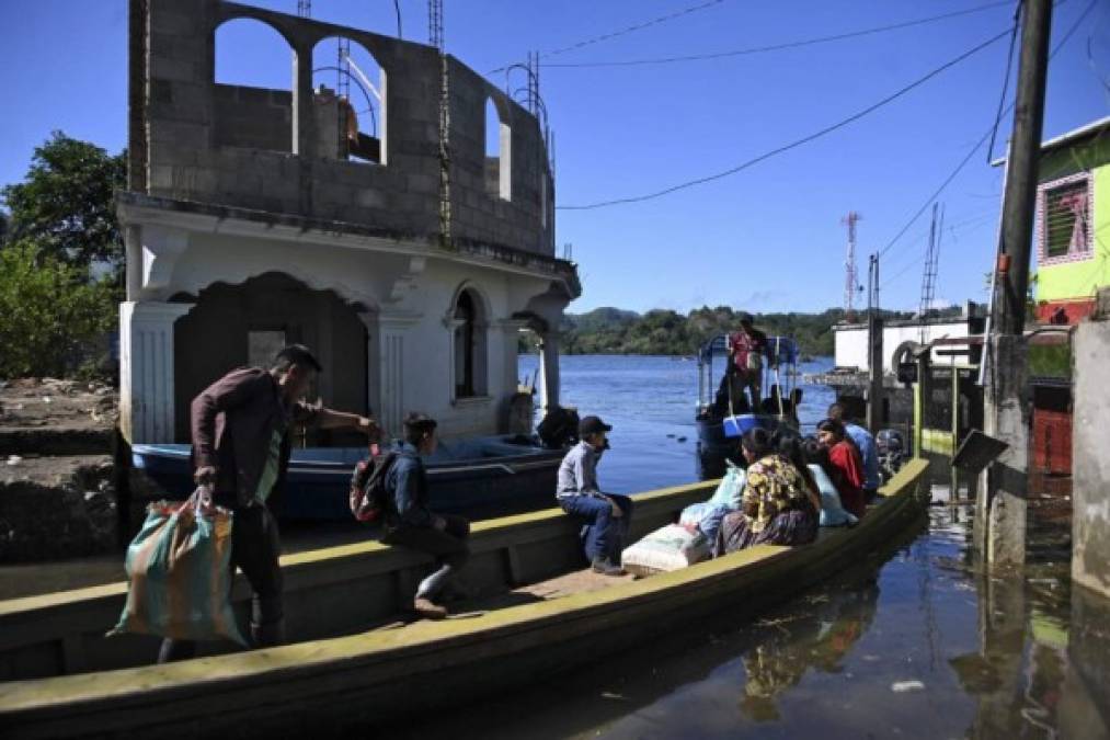 Residentes viajan en bote por una calle inundada de la comunidad indígena Comunidad Campur, Guatemala, el 10 de diciembre de 2020. - La comunidad indígena de Campur en el norte de Guatemala se ha convertido en una laguna luego del paso de los huracanes Eta e Iota, que dejaron 160 muertos y desaparecido en el país. (Foto de Johan ORDONEZ / AFP)