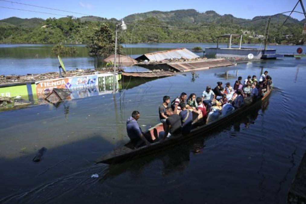 Residentes viajan en bote por una calle inundada de la comunidad indígena Comunidad Campur, Guatemala, el 10 de diciembre de 2020. - La comunidad indígena de Campur en el norte de Guatemala se ha convertido en una laguna luego del paso de los huracanes Eta e Iota, que dejaron 160 muertos y desaparecido en el país. (Foto de Johan ORDONEZ / AFP)