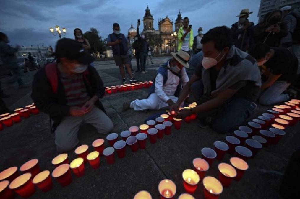 La gente enciende velas durante un homenaje en honor a las más de 9000 personas que murieron por COVID-19 en el país, en la Ciudad de Guatemala, el 26 de junio de 2021. (Foto de Johan ORDONEZ / AFP)