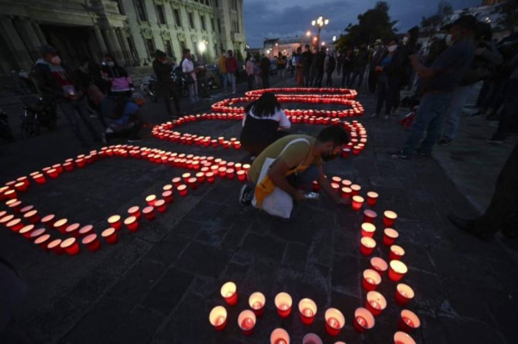La gente enciende velas durante un homenaje en honor a las más de 9000 personas que murieron por COVID-19 en el país, en la Ciudad de Guatemala, el 26 de junio de 2021. (Foto de Johan ORDONEZ / AFP)