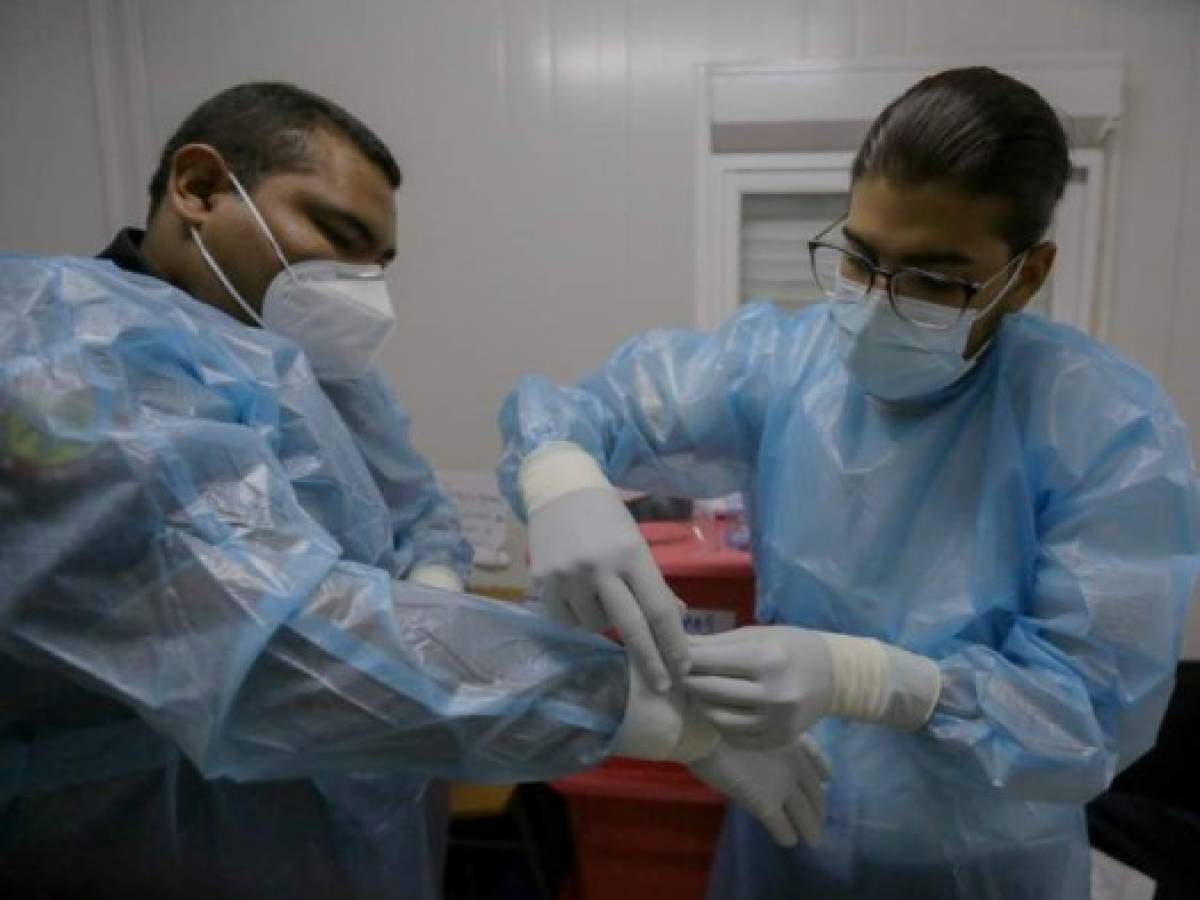 Los paramédicos se preparan para su turno en la ciudad de Panamá el 14 de diciembre de 2020.- Un grupo de paramédicos de la Caja del Seguro Social (CSS) fueron asignados durante la pandemia para atender a los pacientes infectados por Covid-19, brindando atención prehospitalaria y traslados ellos a diferentes hospitales. (Foto de STR / AFP) Los paramédicos se preparan para su turno en la ciudad de Panamá el 14 de diciembre de 2020.- Un grupo de paramédicos de la Caja del Seguro Social (CSS) fueron asignados durante la pandemia para atender a los pacientes infectados por Covid-19, brindando atención prehospitalaria y traslados ellos a diferentes hospitales. (Foto de STR / AFP)