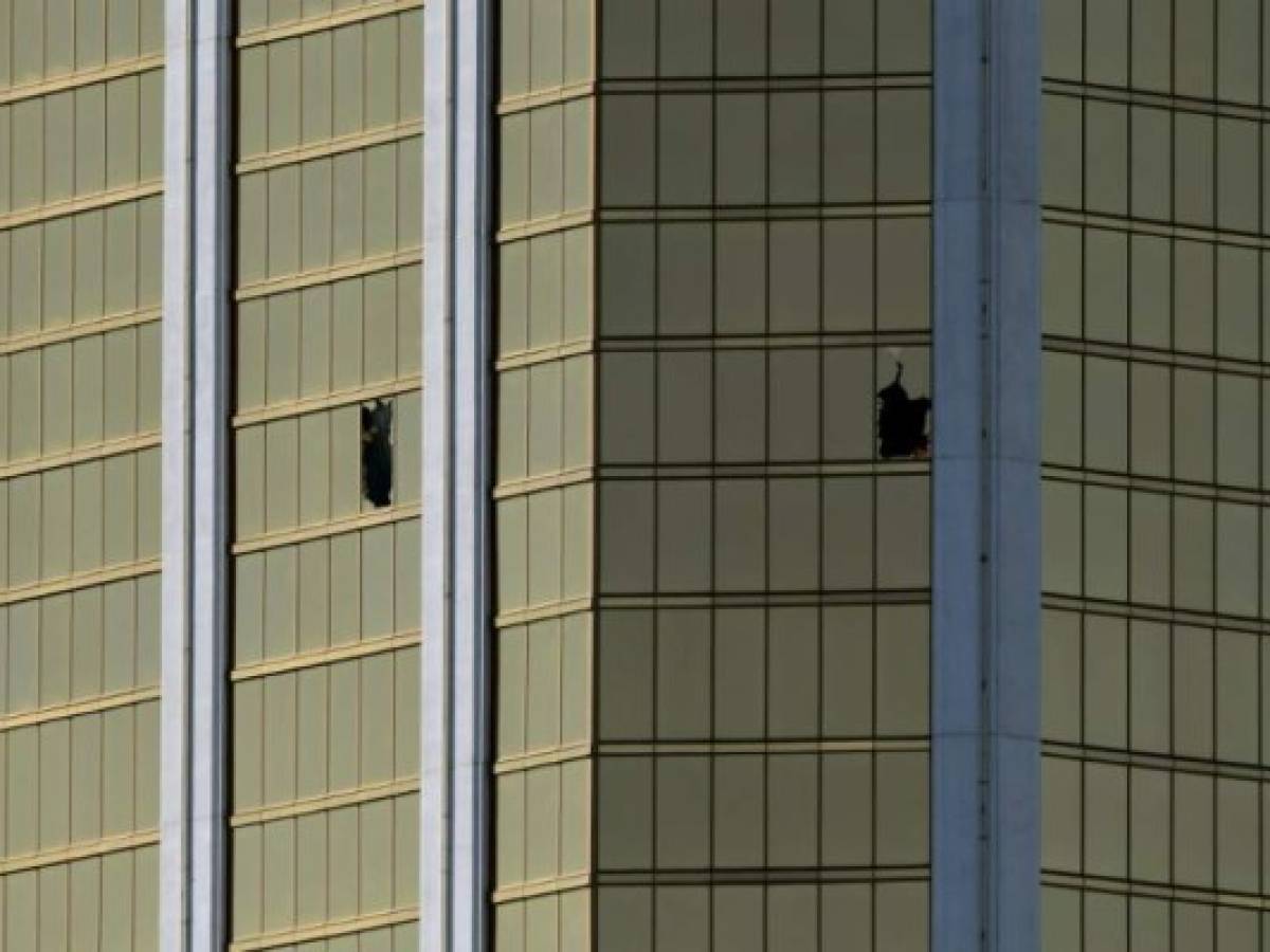 The damaged windows on the 32nd floor room that was used by the shooter in the Mandalay Hotel after a gunman killed at least 58 people and wounded more than 500 others when he opened fire on a country music concert in Las Vegas, Nevada on October 2, 2017. Police said the gunman, a 64-year-old local resident named as Stephen Paddock, had been killed after a SWAT team responded to reports of multiple gunfire from the 32nd floor of the Mandalay Bay, a hotel-casino next to the concert venue. / AFP PHOTO / Mark RALSTON