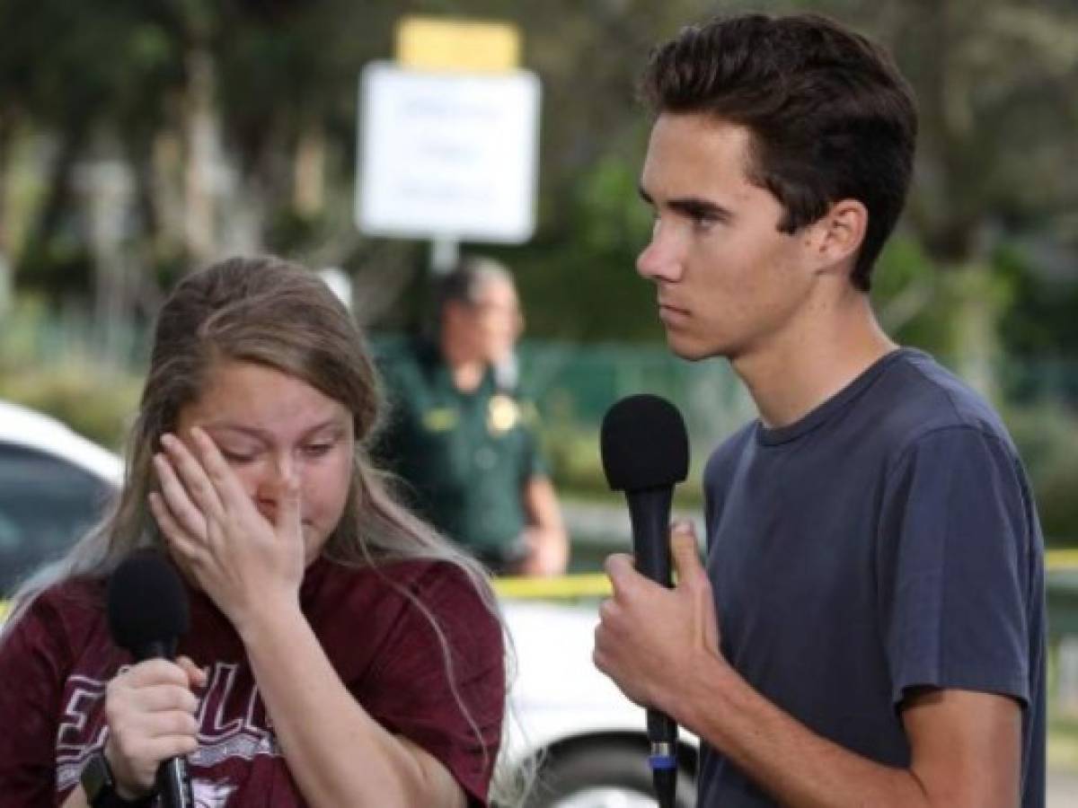 PARKLAND, FLORIDA: Los estudiantes Kelsey Friend (Izq.) y David Hogg escuchan las historias tras el tiroteo en Marjory Stoneman Douglas High School donde 17 personas murieron. Mark Wilson/Getty Images/AFP