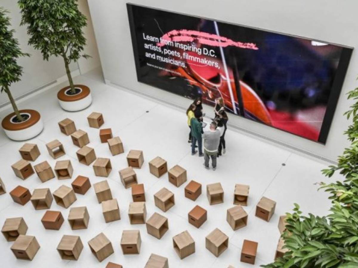 People talk inside the historic Carnegie Library in downtown Washington, DC on May 09, 2019 during an Apple media preview of its 'most ambitious' retail store. - Apple allowed journalists Thursday to view the renovated Carnegie Library in downtown Washington, just blocks from the White House and the Capitol Building, ahead of its public opening on Saturday. Apple funded the renovation under an agreement with local authorities, and will use one of the three floors for its retail store and education programs, with the remainder dedicated to local historical exhibits. (Photo by EVA HAMBACH / AFP)