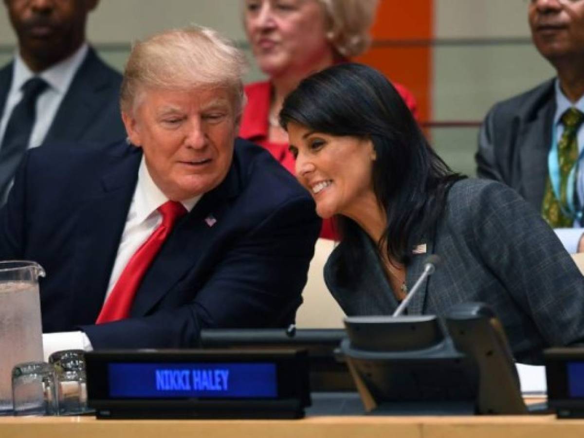 US President Donald Trump and US ambassador to the United Nations Nikki Haley speak during a meeting on United Nations Reform at the United Nations headquarters on September 18, 2017, in New York. / AFP PHOTO / TIMOTHY A. CLARY