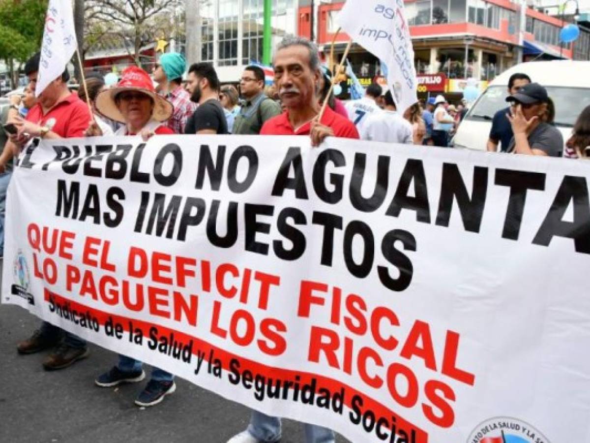 Workers take part in a protest during a nationwide strike called by unions against a new tax bill, in San Jose on April 25, 2018.The government's initiative to strengthen public finances, and face fiscal deficit involves the creation of new taxes to be paid by citizens. / AFP PHOTO / Ezequiel BECERRA