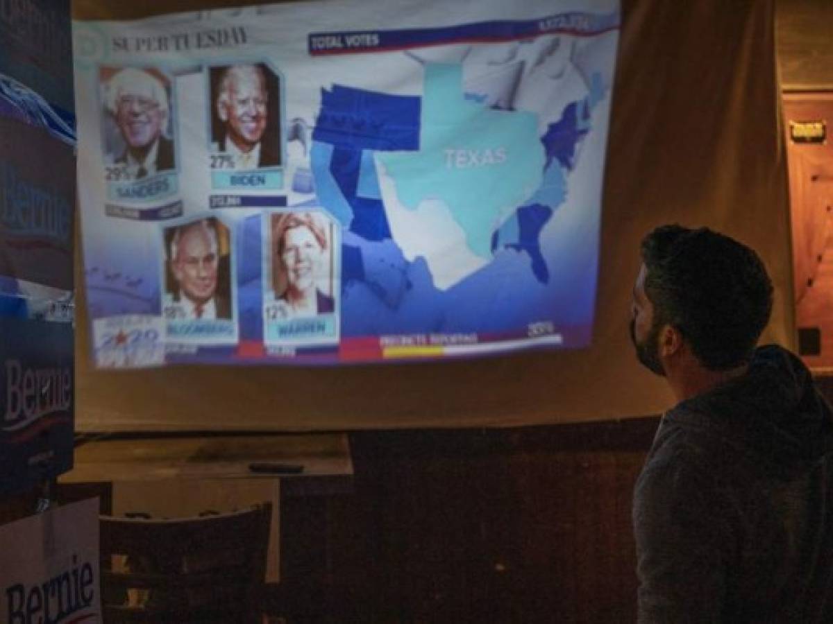 A Bernie Sanders supporter watches the election results come in at the Hoppy Monk bar in El Paso, Texas on March 3, 2020, Super Tuesday. - Fourteen states and American Samoa are holding presidential primary elections, with over 1400 delegates at stake. Americans vote Tuesday in primaries that play a major role in who will challenge Donald Trump for the presidency, a day after key endorsements dramatically boosted Joe Biden's hopes against surging leftist Bernie Sanders. The backing of Biden by three of his ex-rivals marked an unprecedented turn in a fractured, often bitter campaign. (Photo by Paul Ratje / AFP) A Bernie Sanders supporter watches the election results come in at the Hoppy Monk bar in El Paso, Texas on March 3, 2020, Super Tuesday. - Fourteen states and American Samoa are holding presidential primary elections, with over 1400 delegates at stake. Americans vote Tuesday in primaries that play a major role in who will challenge Donald Trump for the presidency, a day after key endorsements dramatically boosted Joe Biden's hopes against surging leftist Bernie Sanders. The backing of Biden by three of his ex-rivals marked an unprecedented turn in a fractured, often bitter campaign. (Photo by Paul Ratje / AFP)