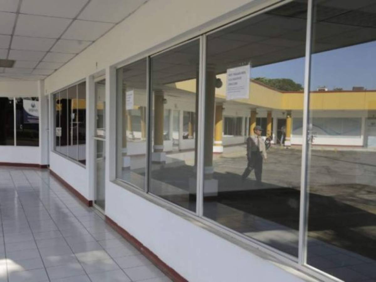 A security guard is reflected in a mirror of a closed store in Managua on August 8, 2018.The political turbulence hit hard on the Nicaraguan economy, leaving devastated tourist cities, closed shopping centers, hotels and restaurants, no credit for agriculture and rife unemployment. / AFP PHOTO / INTI OCON