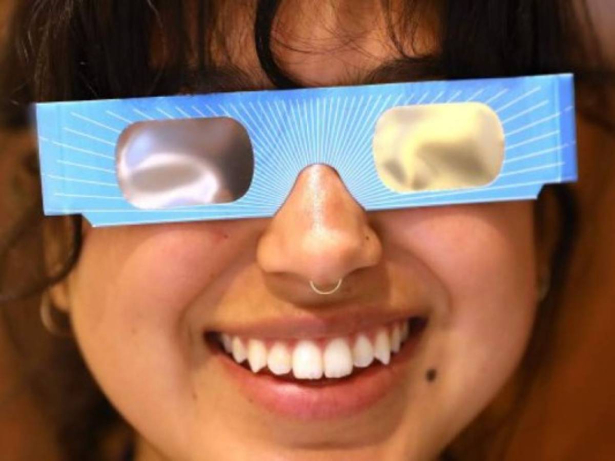 NEW YORK, NY - AUGUST 11: Warby Parker employee Karolyna Landin poses with a pair of solar eclipse glasses that the eyeglass store is giving out for free on August 11, 2017 in New York City. To view the upcoming total solar eclipse on August 21 eye protection is essential. The designer eyeglass store expects to give out thousands of the glasses before the event. Spencer Platt/Getty Images/AFP