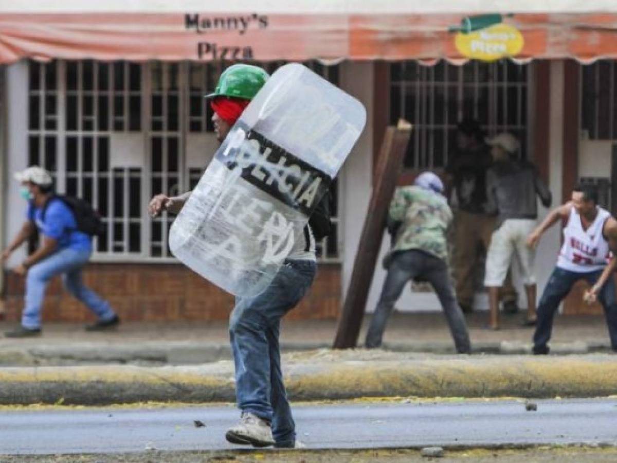 Estudiantes se enfrentan a agentes de policía en protesta por reformas hechas al INSS en Managua el 21 de abril de 2018. AFP PHOTO / INTI OCON