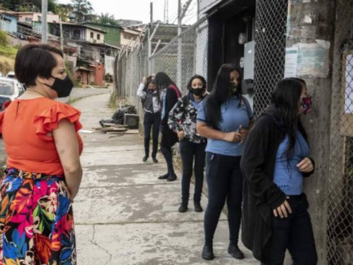 Estudiantes hacen fila para la toma de su temperatura antes de entrar a clases. (Foto Ezequiel BECERRA / AFP)