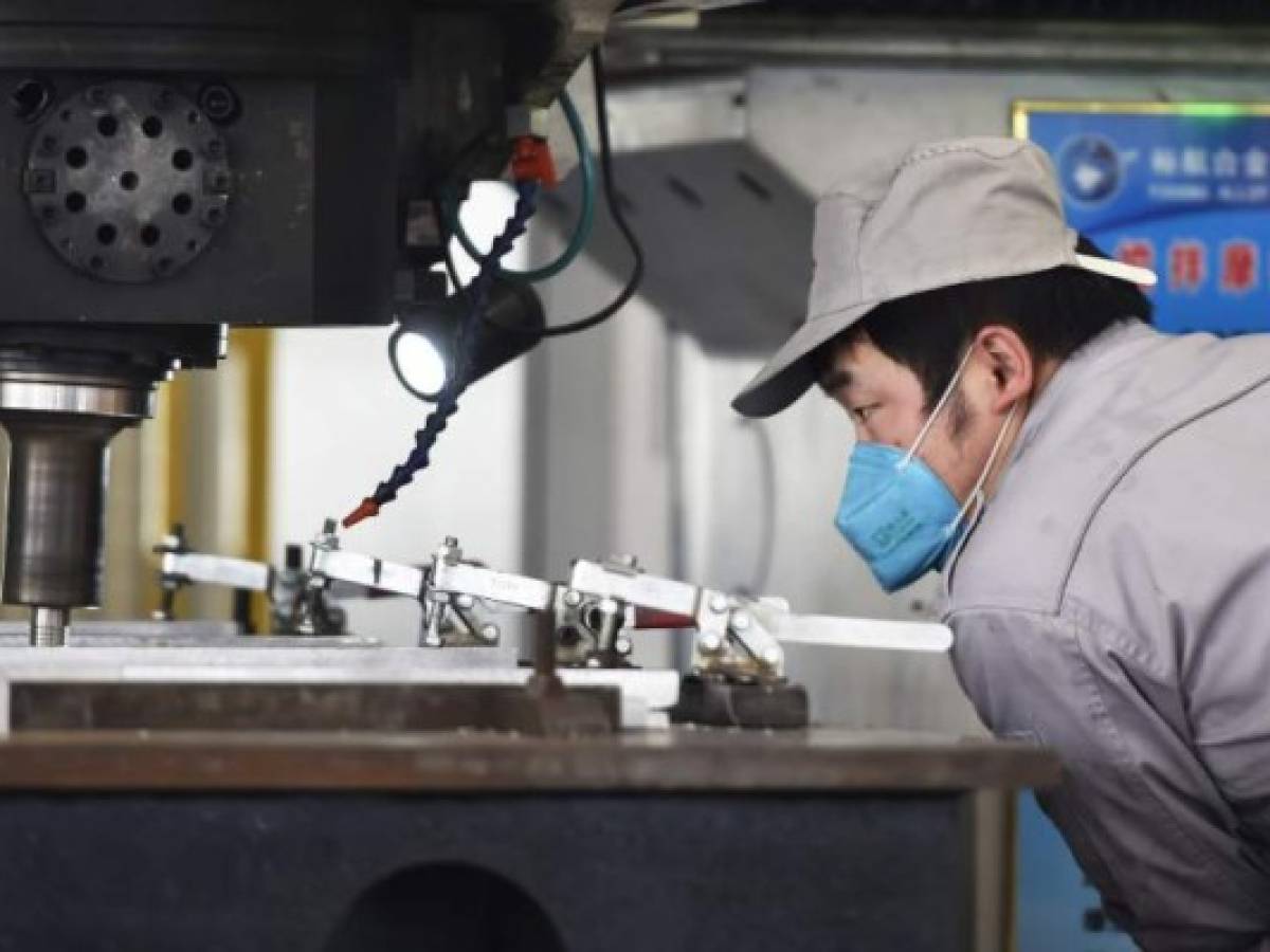 This photo taken on March 14, 2020 shows a worker watching over equipment at an aluminium processing factory in Zouping, in China's Shandong province. - China's industrial production, retail sales and investment all contracted in the first two months of the year after the coronavirus epidemic wreaked havoc on the economy, official data showed on March 16. (Photo by STR / AFP) / China OUT