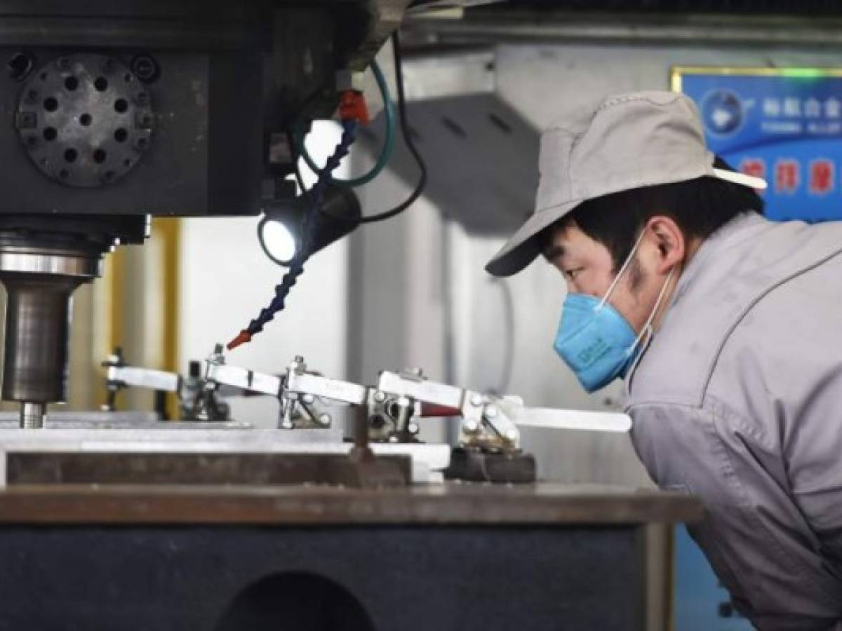 This photo taken on March 14, 2020 shows a worker watching over equipment at an aluminium processing factory in Zouping, in China's Shandong province. - China's industrial production, retail sales and investment all contracted in the first two months of the year after the coronavirus epidemic wreaked havoc on the economy, official data showed on March 16. (Photo by STR / AFP) / China OUT This photo taken on March 14, 2020 shows a worker watching over equipment at an aluminium processing factory in Zouping, in China's Shandong province. - China's industrial production, retail sales and investment all contracted in the first two months of the year after the coronavirus epidemic wreaked havoc on the economy, official data showed on March 16. (Photo by STR / AFP) / China OUT