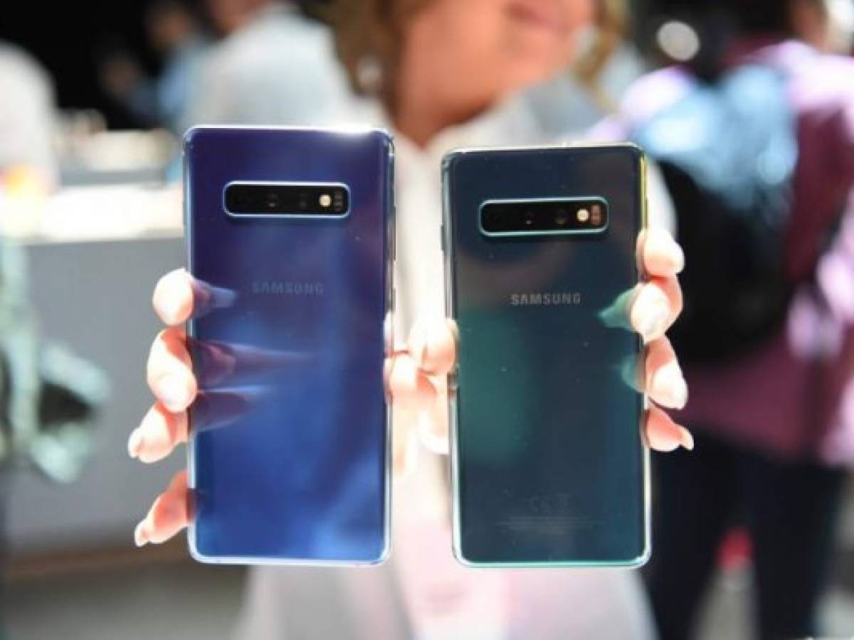 A Samsung employee displays an S10+ (L) and an S10 (R) phone during the Samsung Unpacked product launch event in San Francisco, California on February 20, 2019. - Seeking to rev up demand in the slumping smartphone market, Samsung on Wednesday unveiled a folding handset, becoming the first major manufacturer to offer the feature. (Photo by Josh Edelson / AFP)
