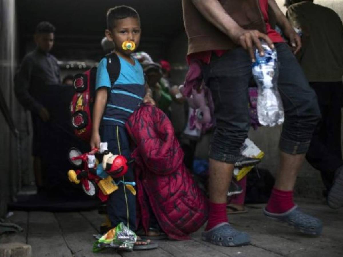 Central American migrants -mostly Hondurans- moving in a caravan towards the United States in hopes of a better life, get off a truck in Tijuana, Mexico after arriving from Mexicali, on November 27, 2018. (Photo by PEDRO PARDO / AFP)