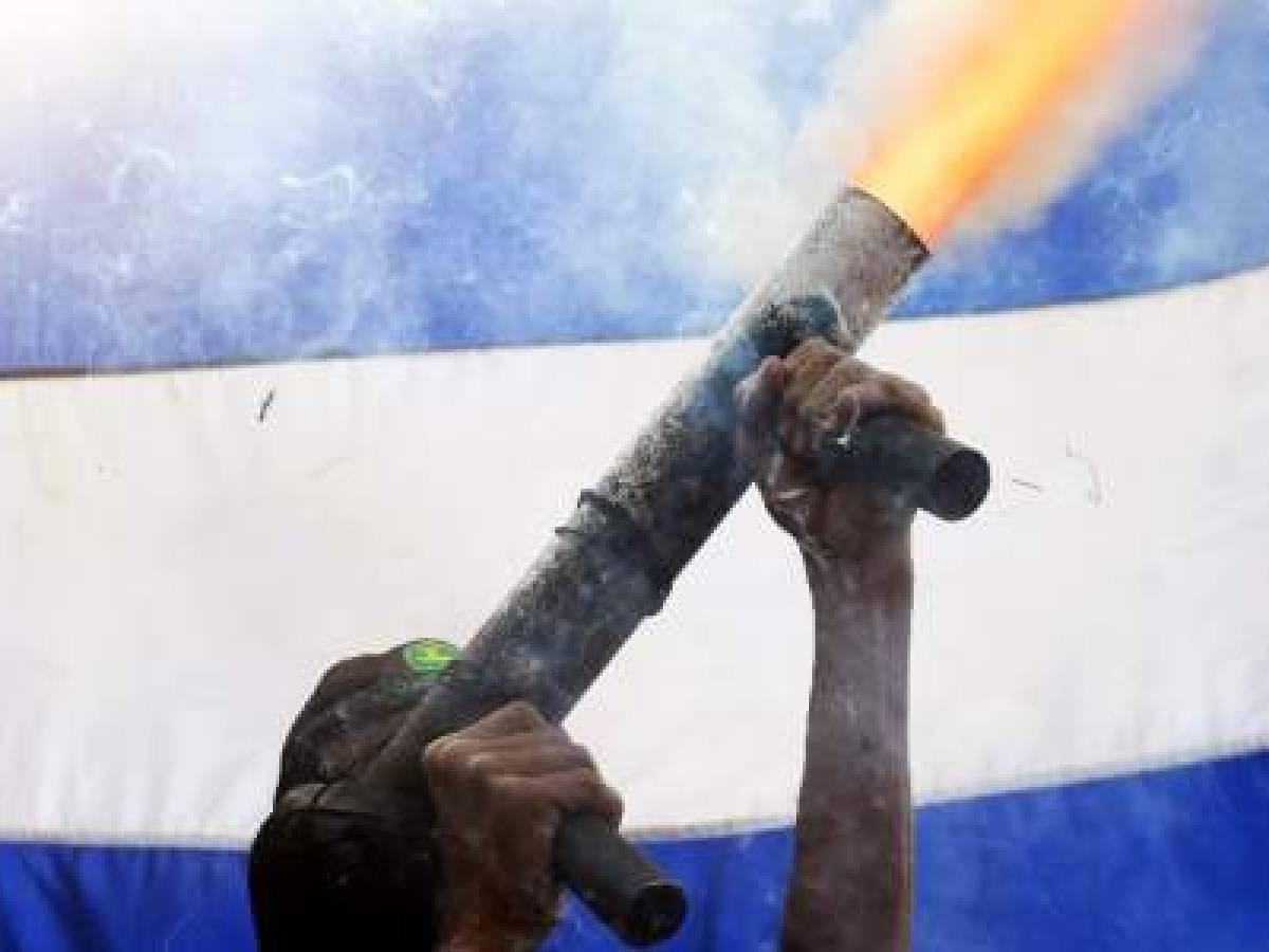 A member of the 'April 19' movement fires his hand-made mortar, after leaders of the movement offered a press conference in Masaya, about 40 km from Managua on June 18, 2018.Students and rights activists reaffirmed during the conference that their struggle is peaceful and civic and called the Nicaraguan army not to get involved. / AFP PHOTO / MARVIN RECINOS