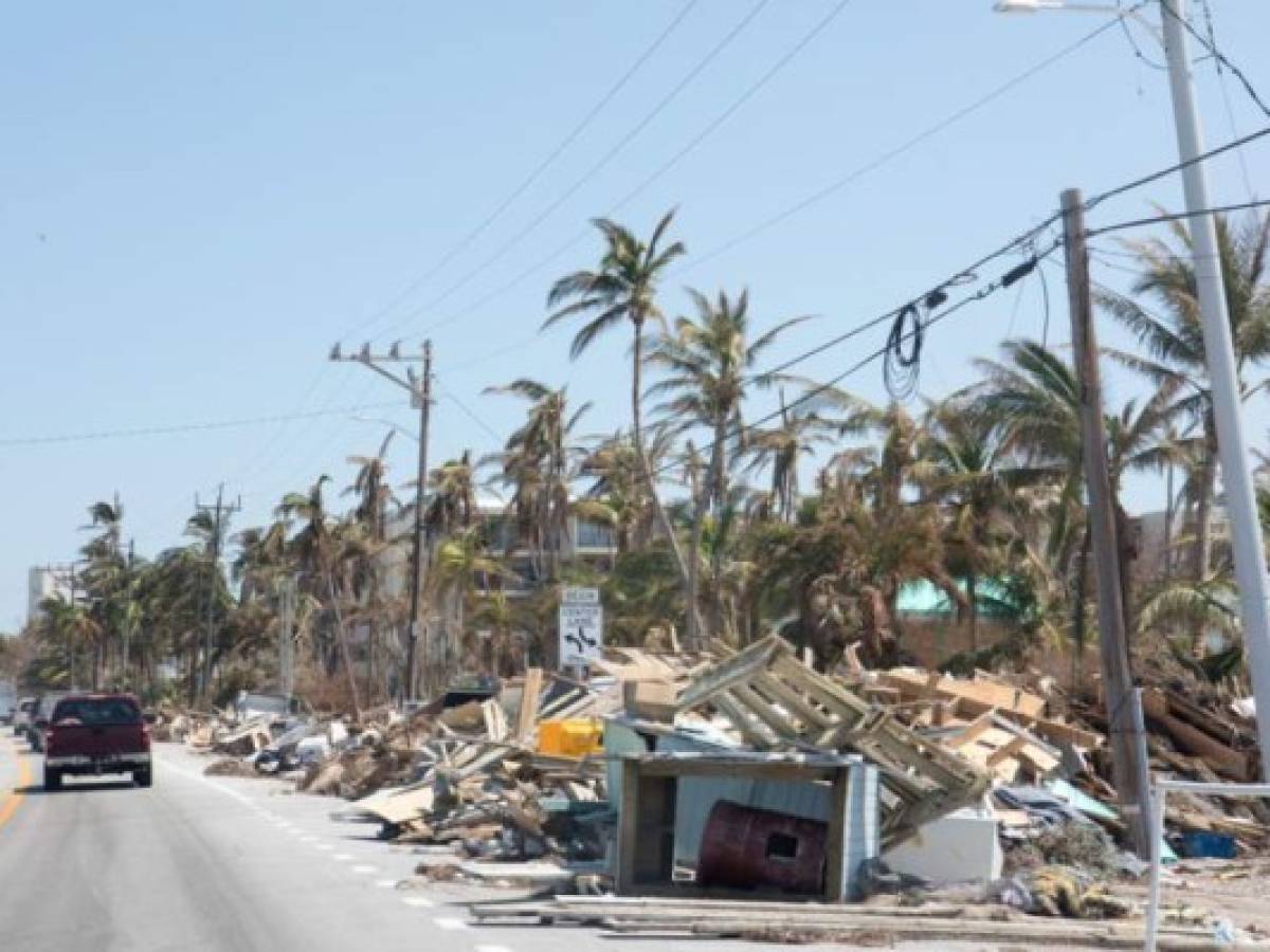 There are mounds of trash and debris placed along side of a roadway after a hurricane hit the Florida Keys. Trees have fallen on power lines causing outages. Shot taken with Canon 5D Mark lV