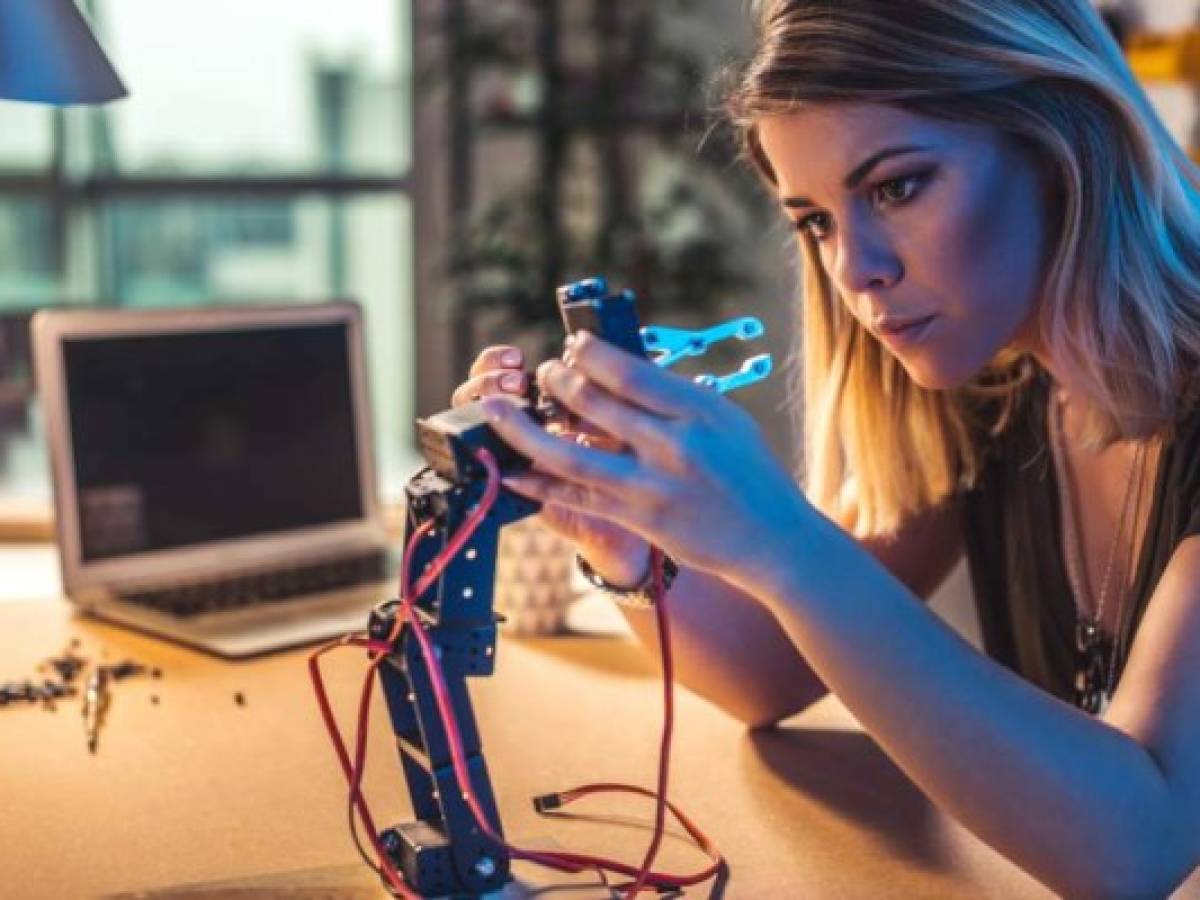 Young woman working in a robotics workshop. Young woman working in a robotics workshop.