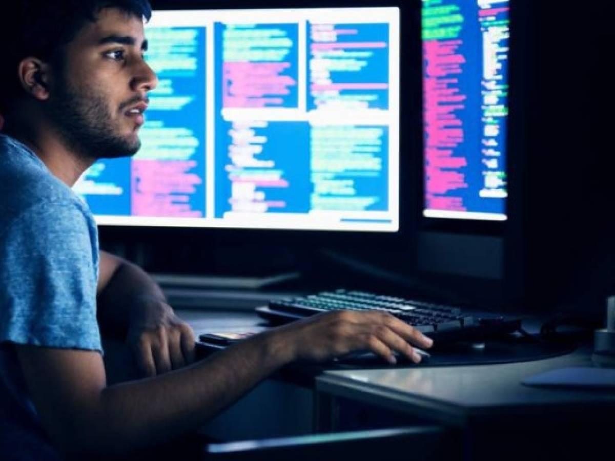 Computer programmer working late on his high tech computer systems