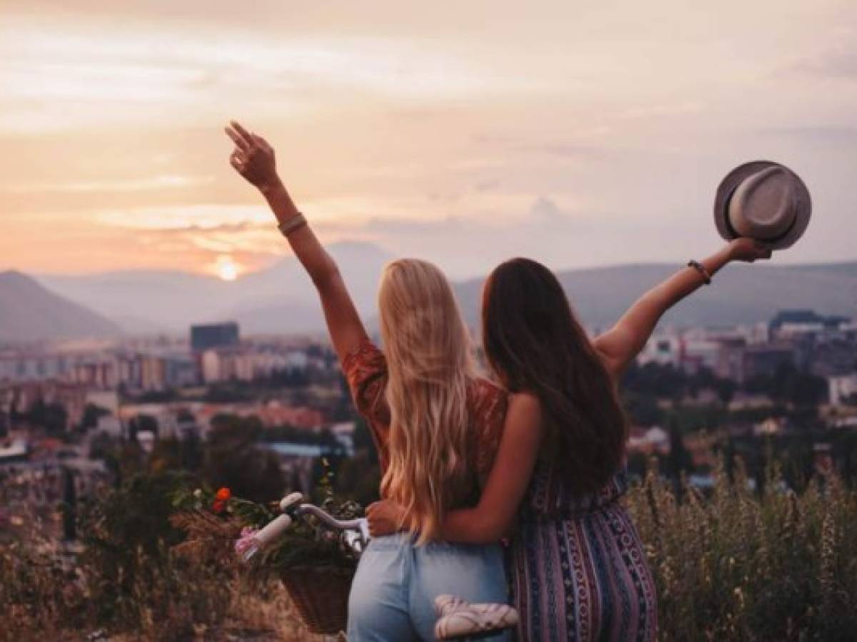Two awesome girls cheering life in front of the sunset