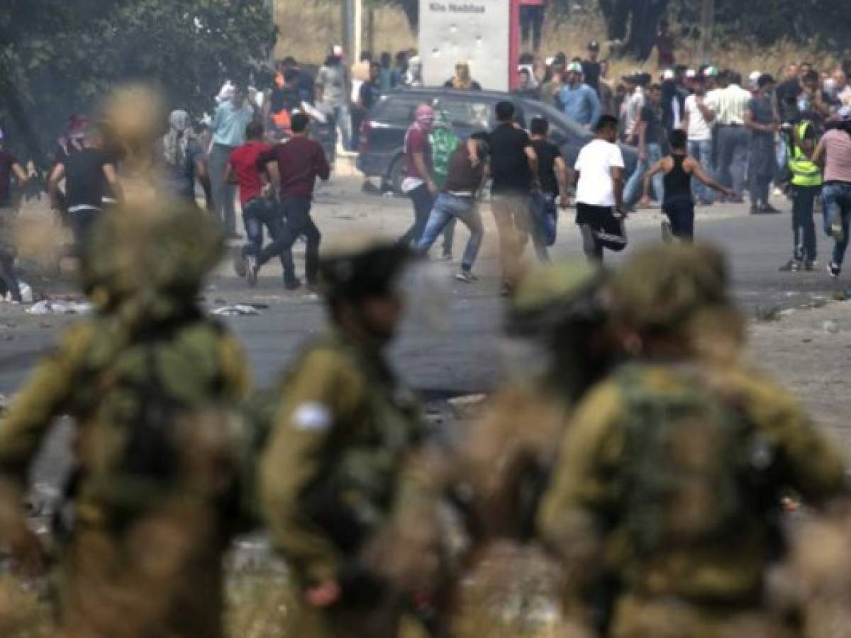 Palestinians clash with Israeli security forces after a protest marking Nakba, or 'catastrophe', commemorating the more than 700,000 Palestinians who fled or were expelled in the 1948 war surrounding Israel's creation, and against the US' relocation of its embassy from Tel Aviv to Jerusalem, at the Hawara checkpoint south of Nablus on May 15, 2018. / AFP PHOTO / JAAFAR ASHTIYEH