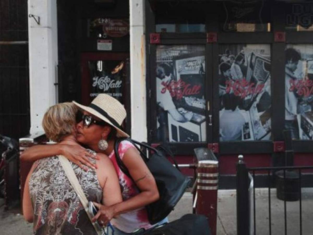 DAYTON, OHIO - AUGUST 04: Nancy Hankey (L) and Kim Nelson hug in front of the Hole In The Wall bar in the Oregon District before the start of a memorial service to recognize the victims of a mass shooting on August 04, 2019 in Dayton, Ohio. Many of the victims were reported to have been shot in front of the bar. At least 9 people were reported to have been killed and another 27 injured when a gunman identified as 24-year-old Connor Betts opened fire with a AR-15 style rifle. The shooting comes less than 24 hours after a gunman in Texas opened fire at a shopping mall killing at least 20 people. Scott Olson/Getty Images/AFP