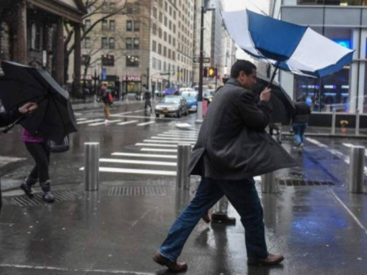 NEW YORK, NY - MARCH 02: A person struggles with their umbrella during a large storm on March 2, 2018 in New York, New York. A nor'easter is set to slam the East Coast on Friday, bringing coastal flooding, heavy snow and strong winds to the area. Stephanie Keith/Getty Images/AFP