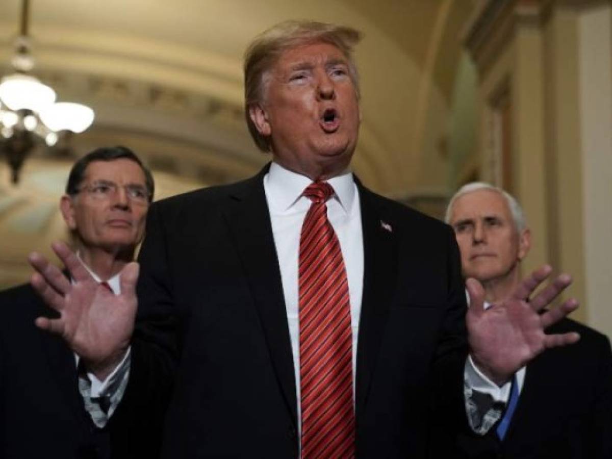 WASHINGTON, DC - JANUARY 09: U.S. President Donald Trump (2nd L) speaks to members of the media as Sen. John Barrasso (R-WY) (L) and Vice President Mike Pence (R) listen at the U.S. Capitol after the weekly Republican Senate policy luncheon January 09, 2019 in Washington, DC. Trump met with GOP lawmakers to shore up their resolve and support for his proposed border wall with Mexico as the partial federal government shutdown drags into a third week. Alex Wong/Getty Images/AFP