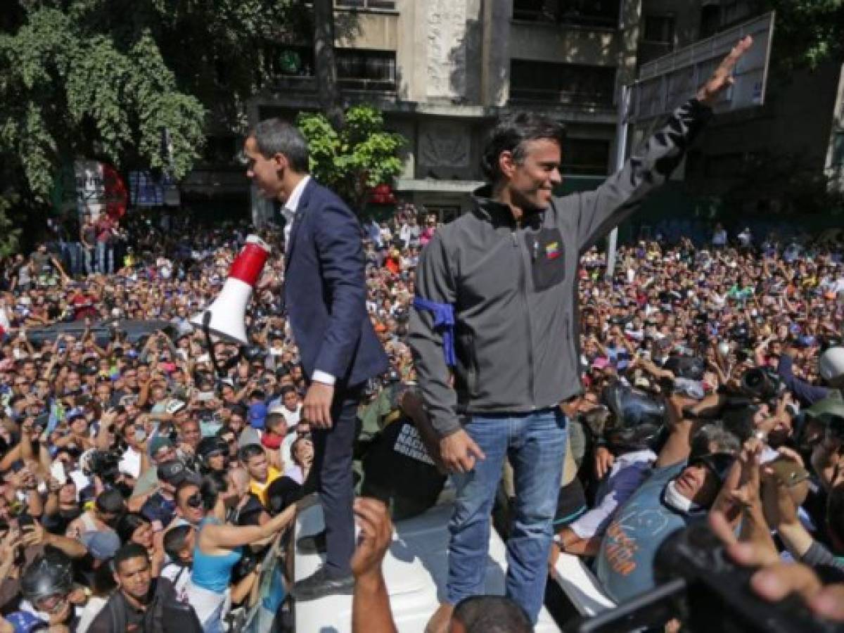 Venezuelan opposition leader and self-proclaimed acting president Juan Guaido (L) and high-profile opposition politician Leopoldo Lopez, who had been put under home arrest by Venezuelan President Nicolas Maduro's regime, greet supporters after being joined by members of the Bolivarian National Guard to oust Maduro, in Caracas on April 30, 2019. - Guaido -- accused by the government of attempting a coup Tuesday -- said there was 'no turning back' in his attempt to oust President Nicolas Maduro from power. (Photo by Cristian HERNANDEZ / AFP) Venezuelan opposition leader and self-proclaimed acting president Juan Guaido (L) and high-profile opposition politician Leopoldo Lopez, who had been put under home arrest by Venezuelan President Nicolas Maduro's regime, greet supporters after being joined by members of the Bolivarian National Guard to oust Maduro, in Caracas on April 30, 2019. - Guaido -- accused by the government of attempting a coup Tuesday -- said there was 'no turning back' in his attempt to oust President Nicolas Maduro from power. (Photo by Cristian HERNANDEZ / AFP)