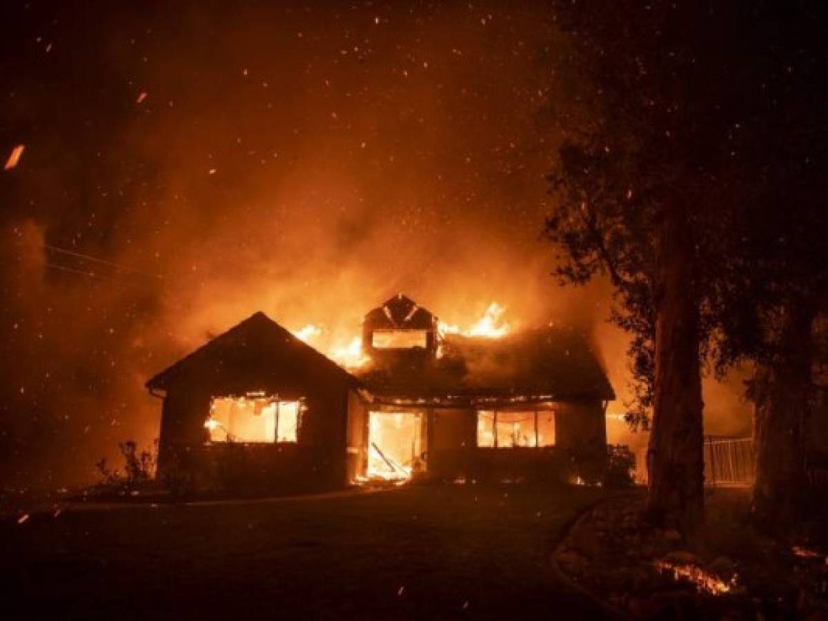 Embers fly through the air as a home burns during the Hillside Fire in the North Park neighborhood of San Bernardino, California, on October 31, 2019. (Photo by Josh Edelson / AFP) Embers fly through the air as a home burns during the Hillside Fire in the North Park neighborhood of San Bernardino, California, on October 31, 2019. (Photo by Josh Edelson / AFP)