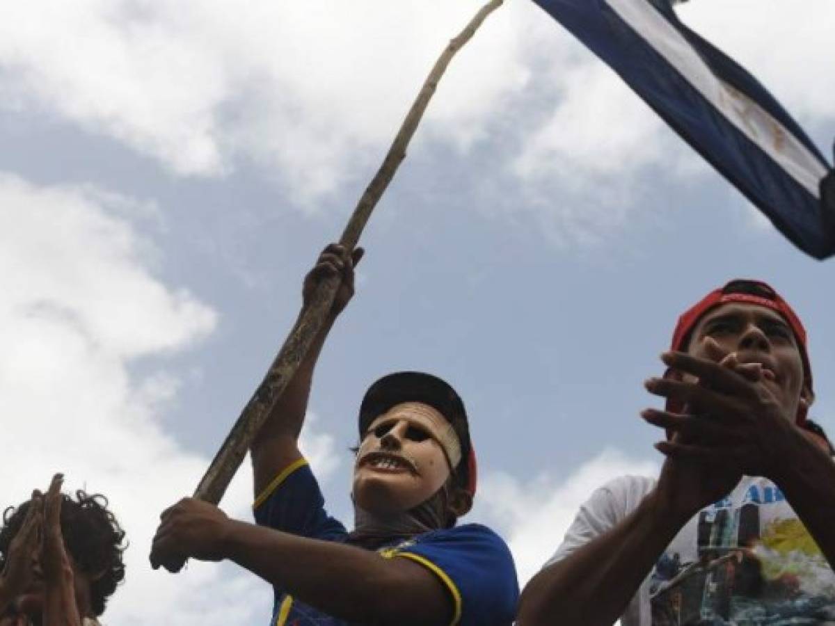 Protesters demand Nicaraguan President Daniel Ortega's resignation and justice for those killed during repression, at the neighbourhood of Monimbo in Masaya, Nicaragua on June 29, 2018.The presence of armed and hooded paramilitaries on the streets of Nicaragua has sparked calls for the army to intervene to end two months of unrest that has killed more than 200 people. / AFP PHOTO / MARVIN RECINOS