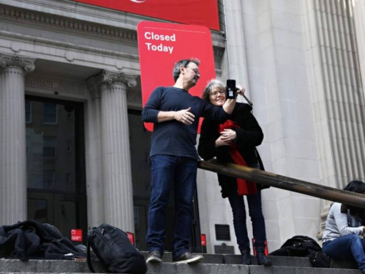 Los turistas toman una foto con un cartel de 'Cerrado hoy' afuera del Museo Metropolitano de Arte el 13 de marzo de 2020 en la ciudad de Nueva York, Estados Unidos. Debido a la continua amenaza del brote de coronavirus (COVID-19) en el país, muchos eventos han sido cancelados. Foto Cindy Ord/Getty Images/AFP