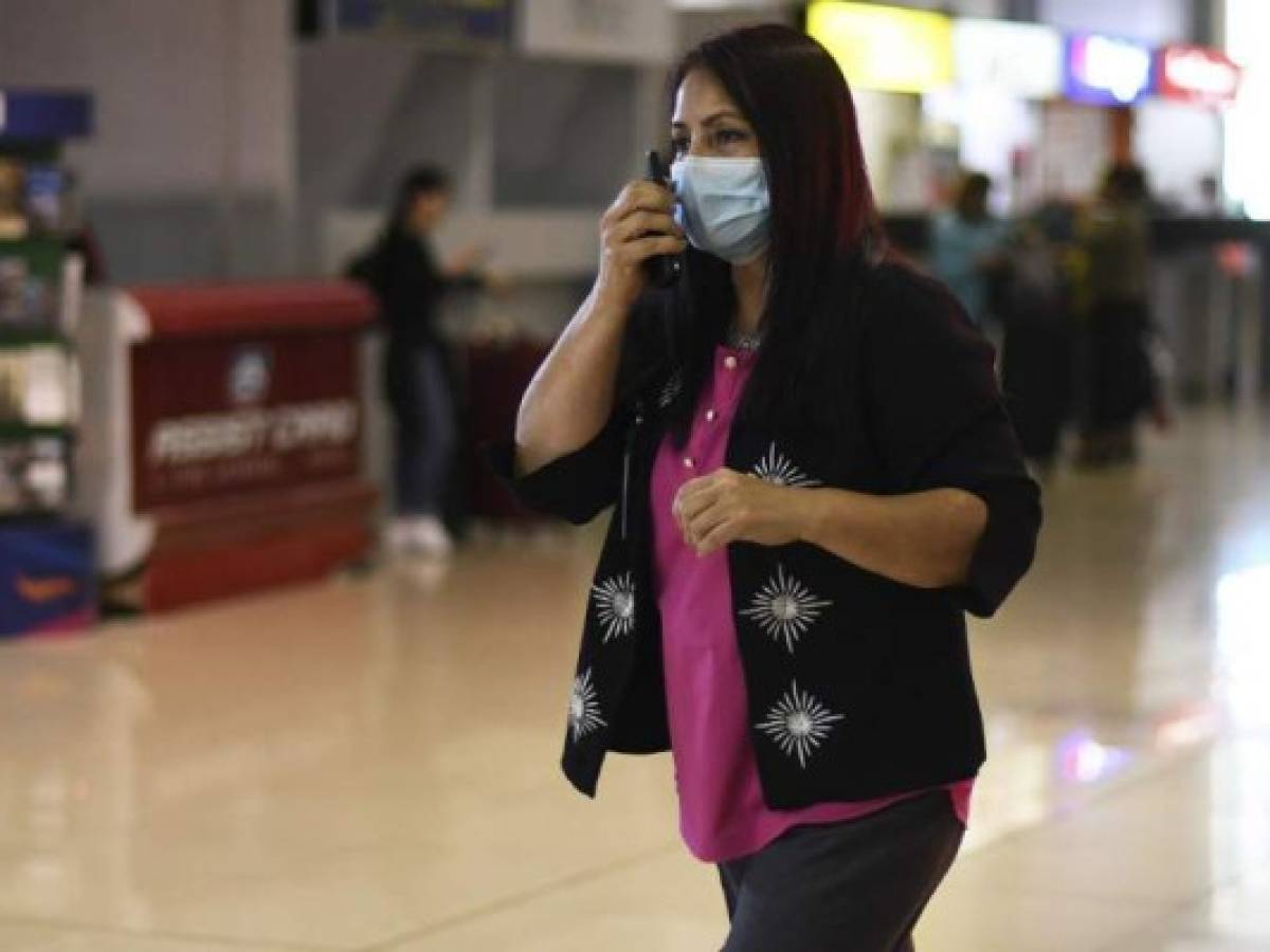 A Guatemalan immigration official wears a face mask as a precaution against the spread of the new coronavirus, at La Aurora International Airport in Guatemala City, on March 12, 2020. (Photo by Johan ORDONEZ / AFP)