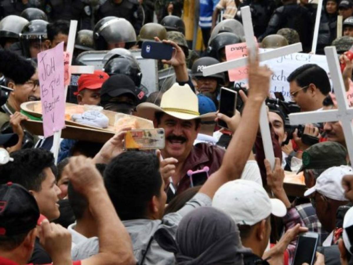 The general coordinator of the Honduran Opposition Alliance Against the Dictatorship, Manuel Zelaya (C), leads a protest outside the Congress building during the instalation of the first legislature of the period 2018-2022, at the National Congress in Tegucigalpa on January 25, 2018.Honduran reelected president Juan Orlando Hernandez, who is to begin his second term on January 27 amid fraud accusations, did not attend the session. / AFP PHOTO / ORLANDO SIERRA