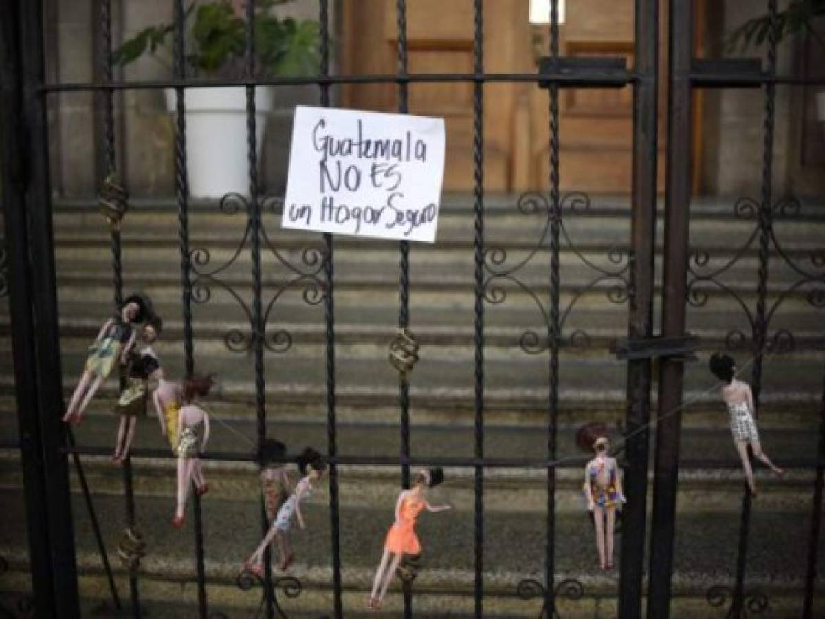 Dolls representing the 29 victims of a fire at government-run children's shelter in San Jose Pinula, east of Guatemala City, are seen on the gate of the presidential house in Guatemala City as part of a demonstration named 'Guatemala is Not a Safe Place' and performed by artists of the group Project 44, on March 9, 2017.Medical officials on Thursday raised the toll of girls killed in a fire at a children's shelter in Guatemala to 29 after seven more died from their burns overnight. More than 30 were injured. / AFP PHOTO / Johan ORDONEZ