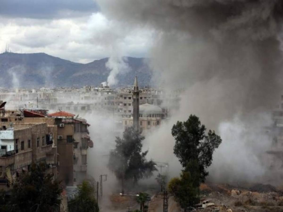 Smoke billows following Syrian government bombardments on Kafr Batna, in the besieged Eastern Ghouta region on the outskirts of the capital Damascus on February 22, 2018. / AFP PHOTO / AMER ALMOHIBANY