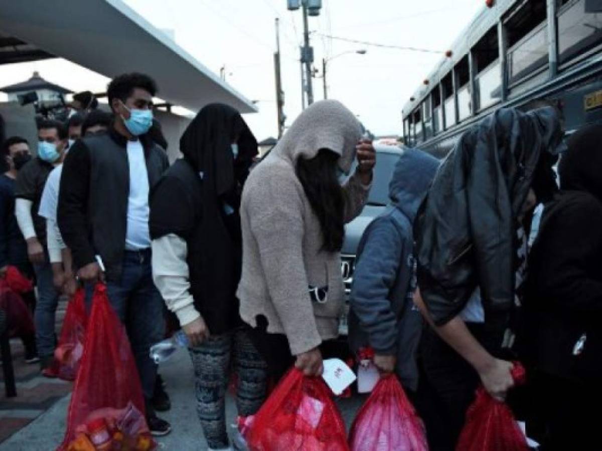 Un grupo de 76 guatemaltecos deportados desde Estados Unidos usan mascarillas como medida preventiva ante el avance del COVID-19. (Foto Johan ORDONEZ / AFP)