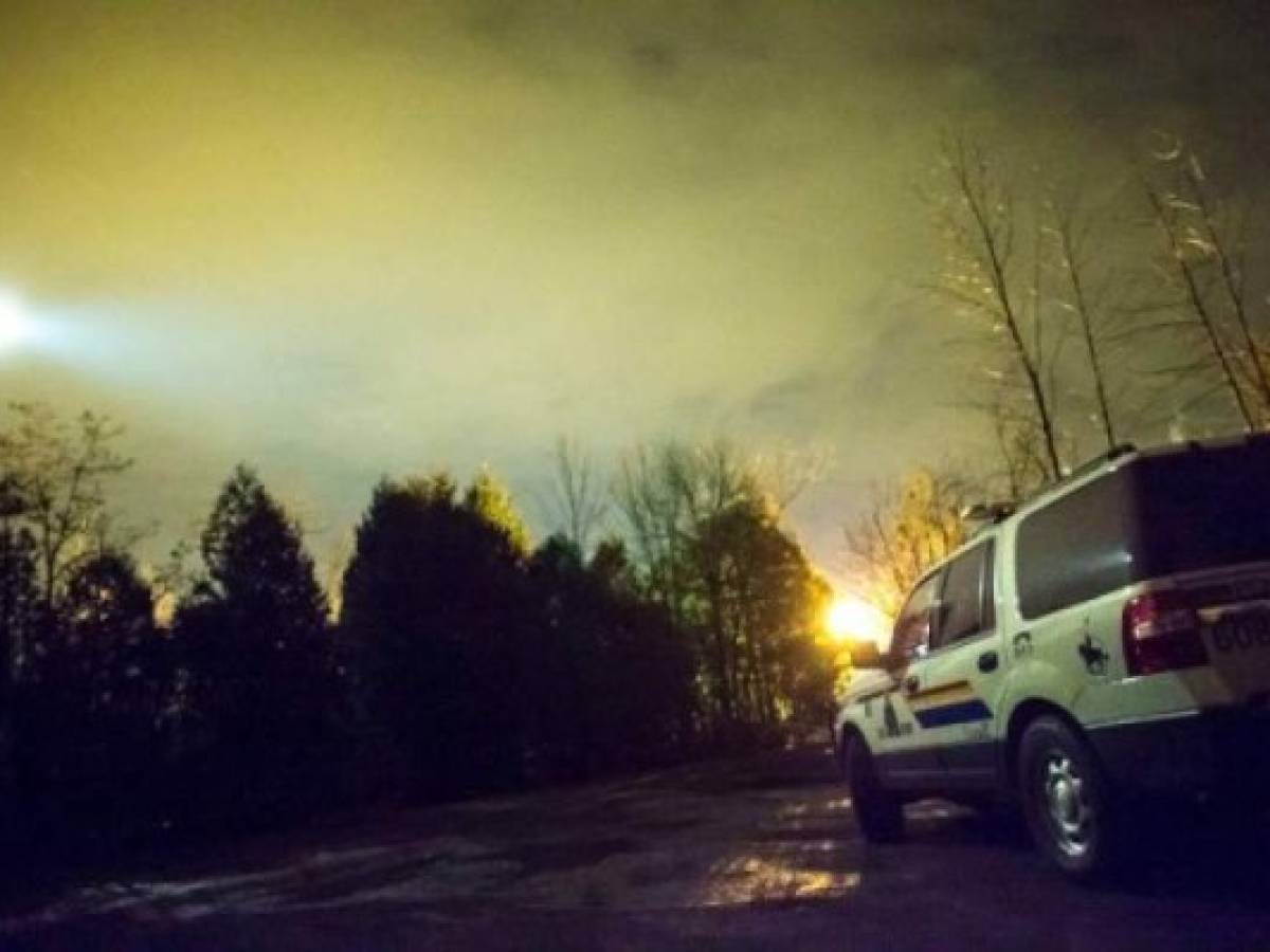 A helicopter with a search light flies over an RCMP vehicle keeping watch over the Canada/US border near Hemmingford, Quebec, February 28, 2017. / AFP PHOTO / Geoff Robins A helicopter with a search light flies over an RCMP vehicle keeping watch over the Canada/US border near Hemmingford, Quebec, February 28, 2017. / AFP PHOTO / Geoff Robins