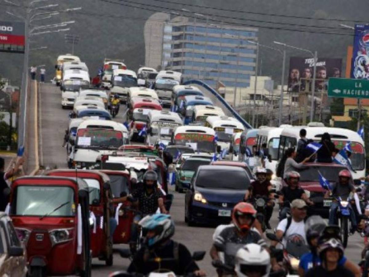 Transport workers protest in demand of a reduction in the price of fuel, in Tegucigalpa, on July 20 2018. Public service transport workers who blocked roads across Honduras last week, demanding the government of President Juan Orlando Hernandez a reduction in the price of fuel, resumed activities on Friday to continue negotiating, but since talks failed they threat to go on strike again on Monday. / AFP PHOTO / ORLANDO SIERRA Transport workers protest in demand of a reduction in the price of fuel, in Tegucigalpa, on July 20 2018. Public service transport workers who blocked roads across Honduras last week, demanding the government of President Juan Orlando Hernandez a reduction in the price of fuel, resumed activities on Friday to continue negotiating, but since talks failed they threat to go on strike again on Monday. / AFP PHOTO / ORLANDO SIERRA