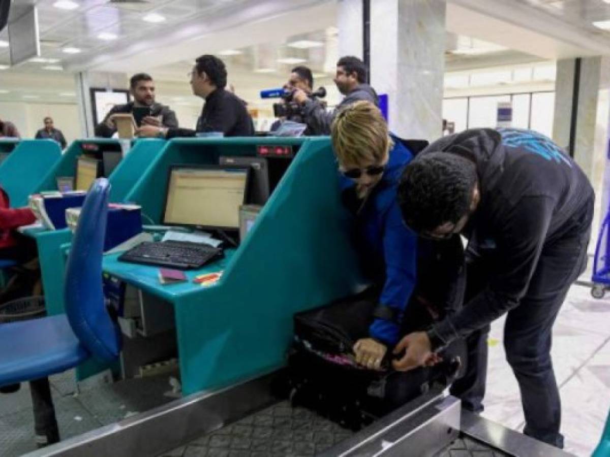 A Tunisian couple bound for London pack away their electronics in their luggage as they check-in for a flight at Tunis-Carthage International Airport on March 25, 2017.The United States this week announced a ban on all electronics larger than a standard smartphone on board direct flights out of eight countries across the Middle East, in effect from March 25, 2017. US officials would not specify how long the ban will last, but Emirates told AFP that it had been instructed to enforce the measures until at least October 14. Britain has also announced a parallel electronics ban targeting all flights out of Egypt, Turkey, Jordan, Saudi Arabia, Tunisia and Lebanon. / AFP PHOTO / FETHI BELAID