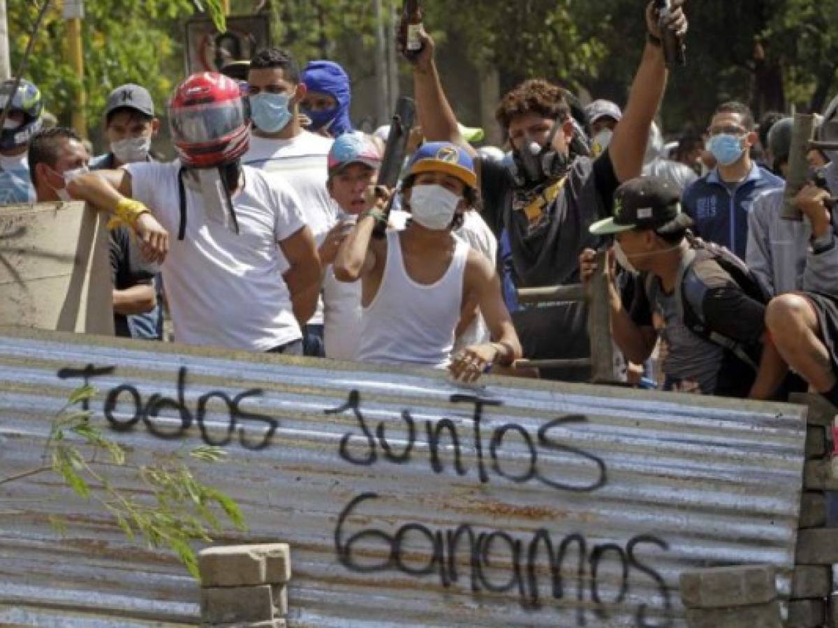 Students wait for riot police agents in a barricade close to Nicaragua's Technical College during protests against government's reforms in the Institute of Social Security (INSS) in Managua on April 21, 2018.Violent protests against a proposed change to Nicaragua's pension system have left at least 10 people dead over two days, the government said Friday. In the biggest protests in President Daniel Ortega's 11 years in office in this poor Central American country, people are angry over the plan because workers and employers would have to chip in more toward the retirement system. / AFP PHOTO / INTI OCON