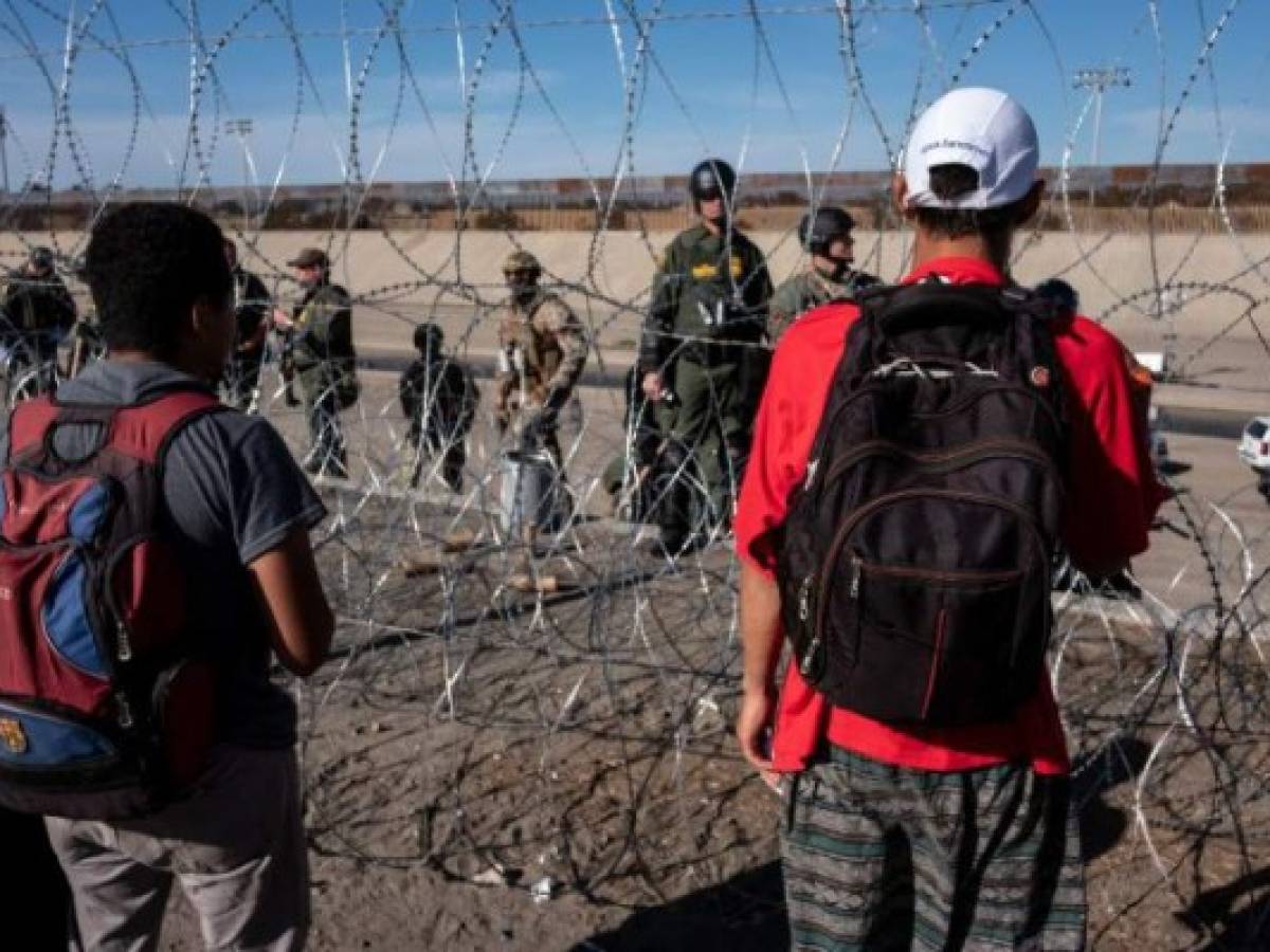 Central American migrants look at US Border Partol officers standing along the bordering Tijuana River near the El Chaparral border crossing in Tijuana, Baja California State, Mexico, on November 25, 2018. - Hundreds of migrants attempted to storm a border fence separating Mexico from the US on Sunday amid mounting fears they will be kept in Mexico while their applications for a asylum are processed. An AFP photographer said the migrants broke away from a peaceful march at a border bridge and tried to climb over a metal border barrier in the attempt to enter the United States. (Photo by Guillermo Arias / AFP)