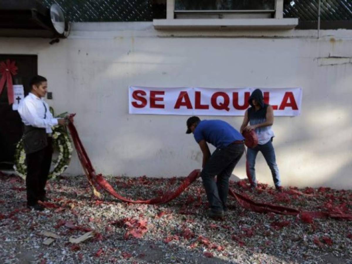 Men set off firecrackers during a protest against the United Nations International Commission Against Impunity, CICIG, next to a 'for rent' sign on the UN-sponsored commission's headquarters, in Guatemala City on January 8,2019. - Guatemalan President Jimmy Morales announced an immediate end to the UN-sponsored anti-corruption commission, CICIG, on January 7. (Photo by NOÉ PÉREZ / AFP)