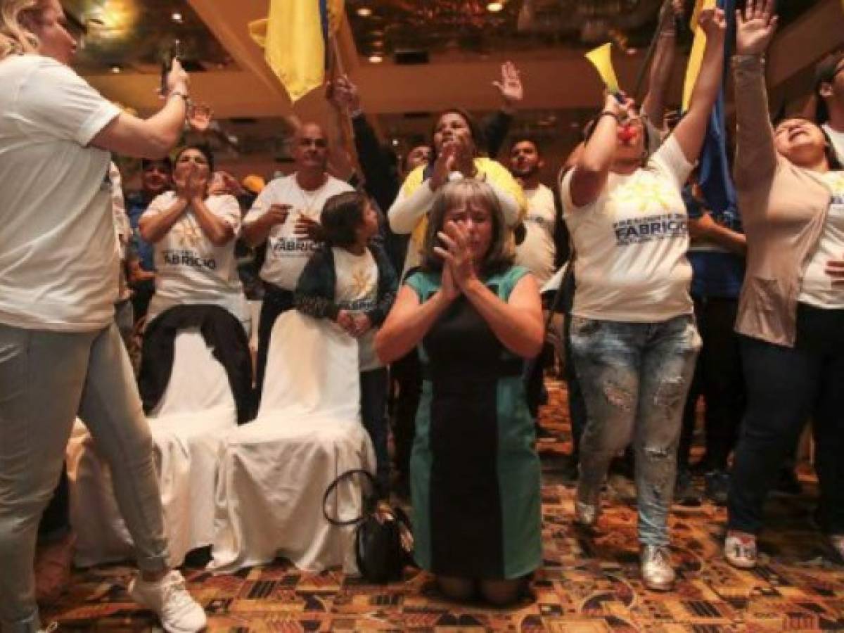 Supporters of Costa Rica's National Restoration Party candidate Fabricio Alvarado react to the partial poll results for the presidential elections, in San Jose on February 4, 2018.The polls in Costa Rica closed Sunday after presidential elections that went smoothly, without any incidents reported, and with a broad turnout. / AFP PHOTO / Jorge RENDON