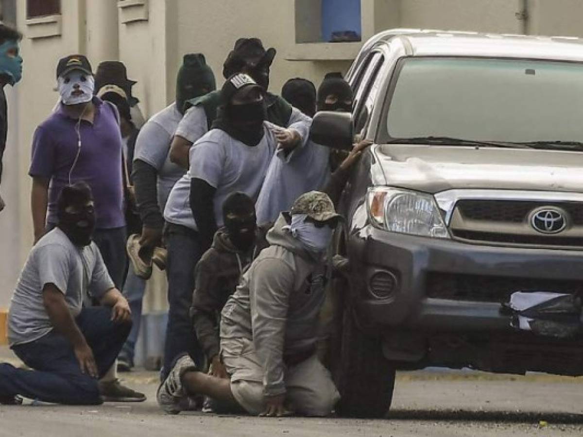 (FILES) In this file photo taken on July 9, 2018, paramilitaries surround the San Sebastian Basilica, in Diriamba, Nicaragua.The known death toll from a four-month crackdown on anti-government protests in Nicaragua has risen to 264, the Inter-American Commission on Human Rights said July 11, 2018. 'As recorded by the IACHR since the start of the repression against social protests, to date, 264 people have lost their lives and more than 1,800 have been injured,' the commission's chief Paulo Abrao told reporters.He was speaking at a meeting of the Organization of American States -- of which the IACHR is part -- about the situation in the violence-wracked Central American country, where protesters are seeking the ouster of President Daniel Ortega. / AFP PHOTO / MARVIN RECINOS