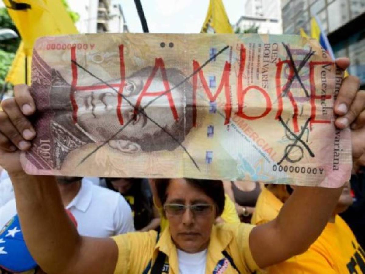 An activist of Venezuela's opposition holds a fake bill reading 'Hunger' during a demonstration in Caracas against the gouverment of Nicolas Maduro, on September 19, 2015. AFP PHOTO / FEDERICO PARRA (Photo credit should read FEDERICO PARRA/AFP/Getty Images)