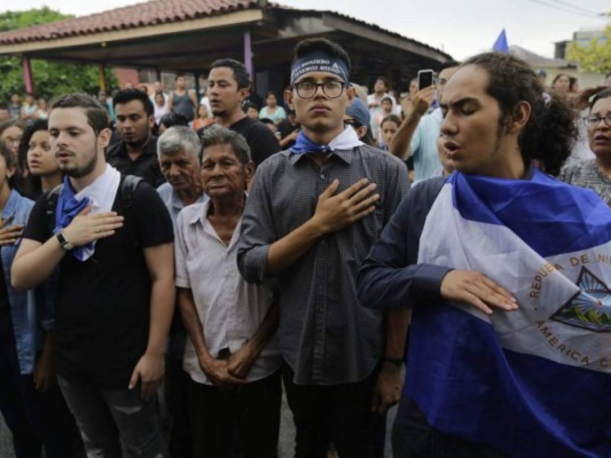 University students' leader Lesther Aleman (C) holds a Nicaraguan national flag flanked to fellow students and opposition members on his arrival at Augusto C. Sandino Airport in Managua on October 07, 2019, after a year in exile. - The Central American state, led since 2006 by Ortega, has been gripped by crisis since April 2018, when opposition protests mushroomed into a popular uprising that was met with a brutal crackdown. Political violence left more than 300 people dead and 2,000 wounded, according to rights groups, while hundreds of opposition supporters were jailed and tens of thousands of people fled the country. (Photo by Maynor Valenzuela / AFP)