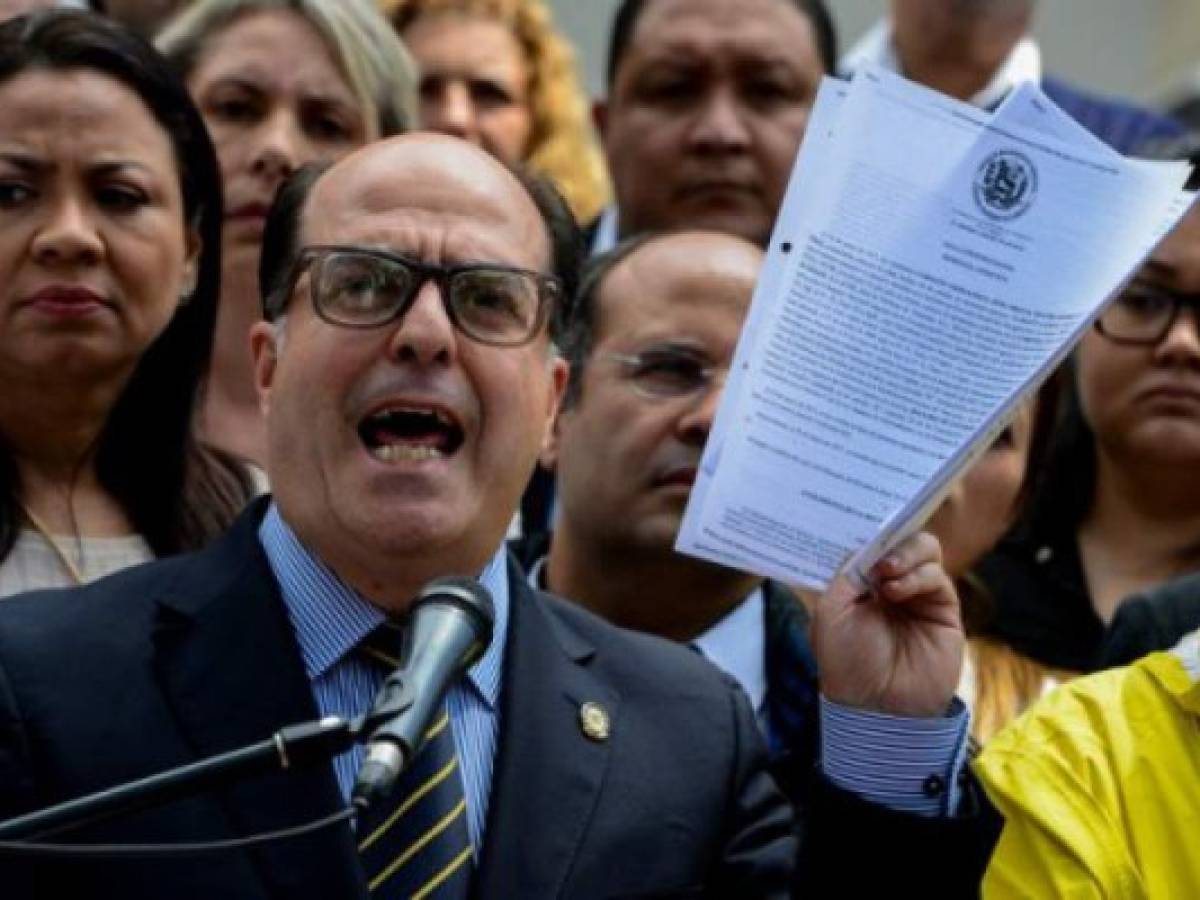 The president of Venezuela's National Assembly Julio Borges, holds a copy of a sentence from Venezuela's Supreme Court granting itself legislative powers, as he speaks during a press conference in Caracas on March 30, 2017.Venezuela's Supreme Court took over legislative powers Thursday from the opposition-majority National Assembly, whose speaker accused leftist President Nicolas Maduro of staging a 'coup.' / AFP PHOTO / FEDERICO PARRA The president of Venezuela's National Assembly Julio Borges, holds a copy of a sentence from Venezuela's Supreme Court granting itself legislative powers, as he speaks during a press conference in Caracas on March 30, 2017.Venezuela's Supreme Court took over legislative powers Thursday from the opposition-majority National Assembly, whose speaker accused leftist President Nicolas Maduro of staging a 'coup.' / AFP PHOTO / FEDERICO PARRA