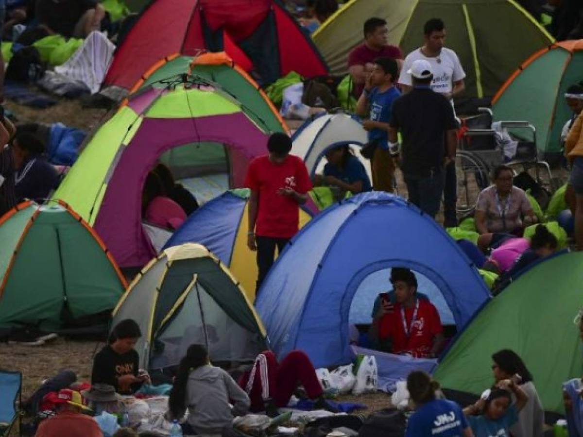 Pilgrims who took part in an evening vigil wait in the early morning for the arrival of Pope Francis to officiate an open-air mass on World Youth Day, at the Campo San Juan Pablo II on the outskirts of Panama City, on January 27, 2019. - Pope Francis winds up a global gathering of young Catholics on Sunday with a giant open-air mass for hundreds of thousands of pilgrims before leaving Panama. (Photo by Luis ACOSTA / AFP)