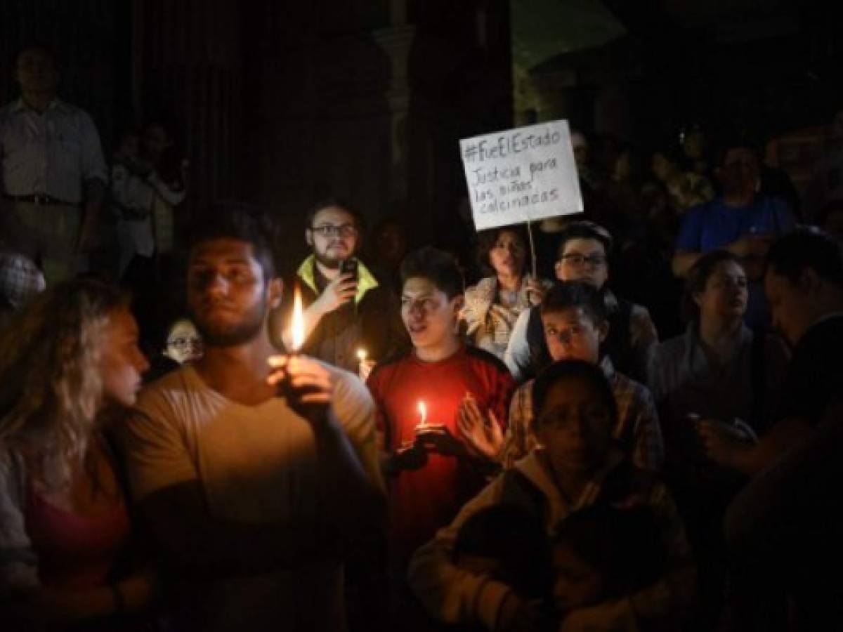 People shout slogans demanding the resignation of Guatemalan President Jimmy Morales during a demonstration outside the Culture Palace in Guatemala City on March 9, 2017, following the death of 34 girls in a recent fire at a government-run children's shelter in San Jose Pinula, east of the capital.Guatemala recoiled in anger and shock Thursday at the deaths of 34 teenage girls in a fire at a government-run shelter where staff have been accused of sexual abuse and other mistreatment. Around 20 more survivors remained hospitalized, most of them in critical condition, according to hospital officials. / AFP PHOTO / JOHAN ORDONEZ